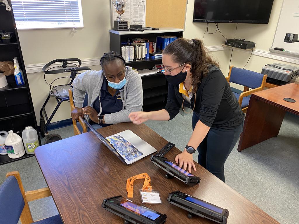 Maria from ReaXium and a Pembroke Pines school admin looking at the student ridership solution